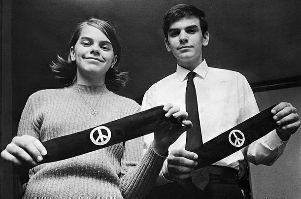black and white photograph of Mary Beth and John Tinker holding black armbands with white peach symbols